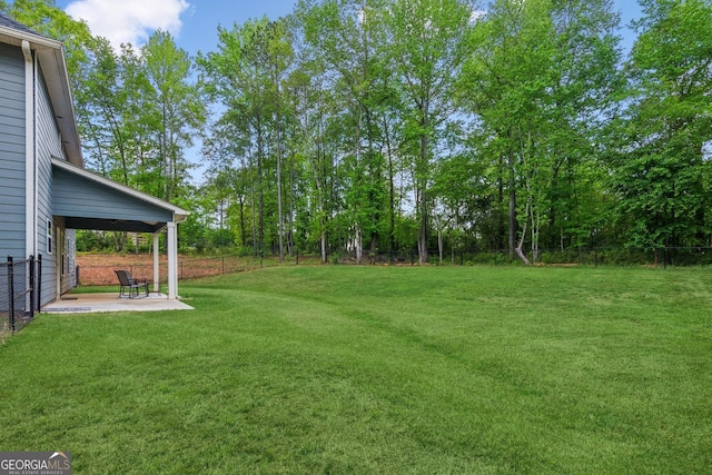view of yard with fence and a patio
