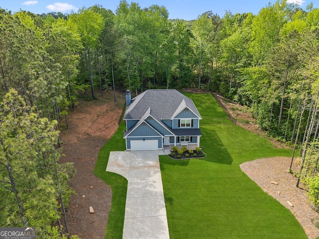 bird's eye view with a wooded view