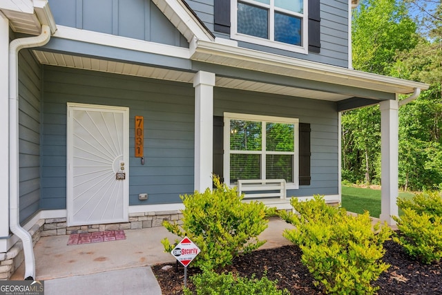 doorway to property with a porch and board and batten siding