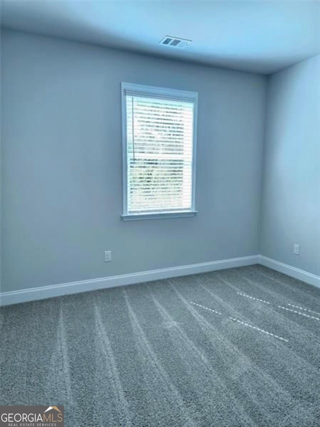 unfurnished room with baseboards, carpet floors, and visible vents
