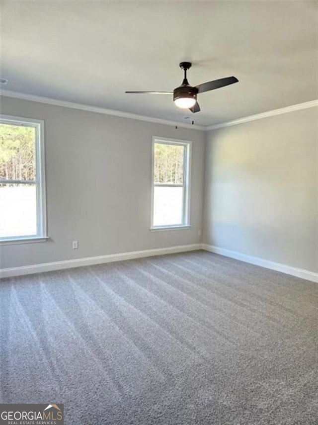 carpeted spare room with baseboards, ornamental molding, and a ceiling fan