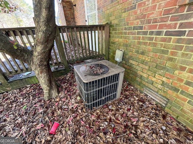 exterior details featuring central AC unit and brick siding