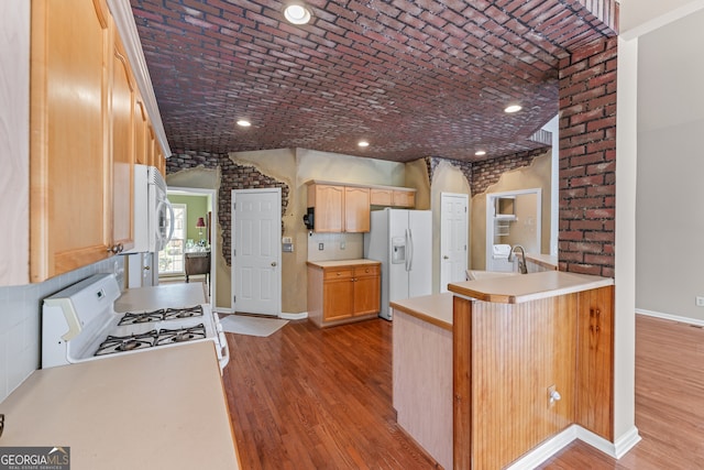 9255 Old Preserve Trl, Ball Ground, GA 30107 - kitchen featuring white appliances, wood finished floors, a peninsula, brick ceiling, and light countertops