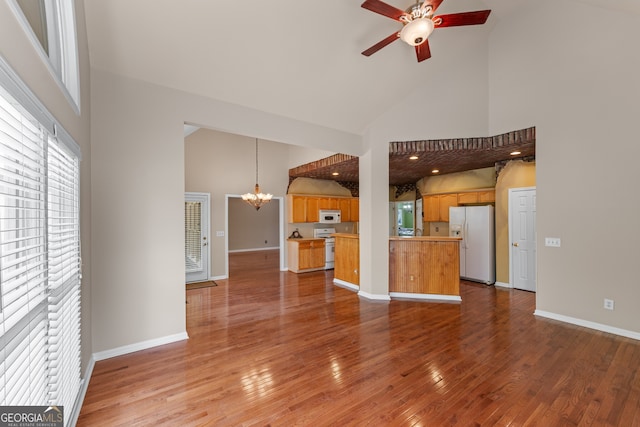 9255 Old Preserve Trl, Ball Ground, GA 30107 - unfurnished living room featuring high vaulted ceiling, a chandelier, a ceiling fan, and wood-type flooring
