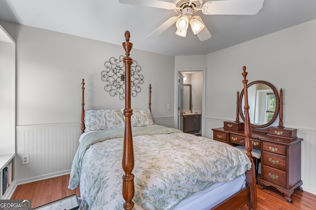 9255 Old Preserve Trl, Ball Ground, GA 30107 - bedroom with light wood finished floors, a wainscoted wall, a ceiling fan, and ensuite bath