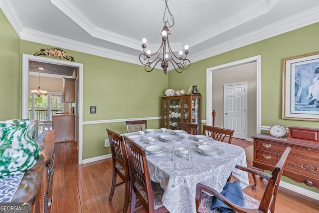 9255 Old Preserve Trl, Ball Ground, GA 30107 - dining area featuring a chandelier, wood-type flooring, ornamental molding, and a raised ceiling