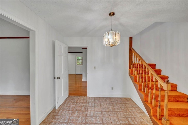interior space featuring stairway, a chandelier, and baseboards