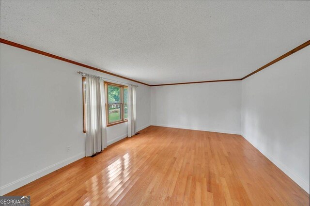 208 Earlwood Dr, Dublin, GA 31021 - empty room featuring ornamental molding, light wood finished floors, a textured ceiling, and baseboards