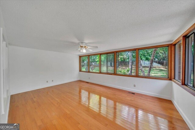 208 Earlwood Dr, Dublin, GA 31021 - unfurnished room with a textured ceiling, visible vents, a ceiling fan, and light wood finished floors