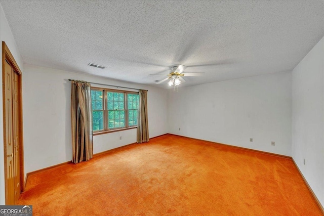 spare room with visible vents, ceiling fan, a textured ceiling, and light colored carpet
