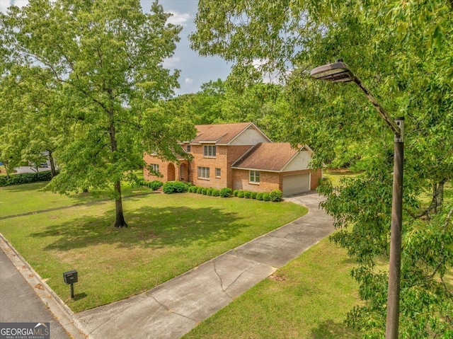 view of front of house featuring concrete driveway, a front yard, brick siding, and a garage