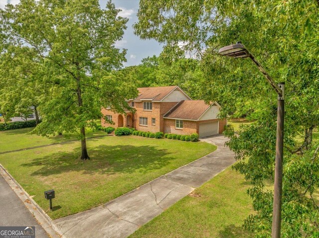 208 Earlwood Dr, Dublin, GA 31021 - view of front of house featuring concrete driveway, a front yard, brick siding, and a garage