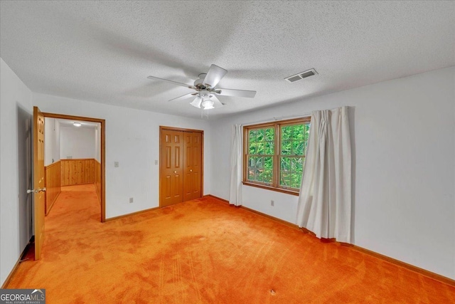 unfurnished bedroom with light colored carpet, a closet, visible vents, a ceiling fan, and a textured ceiling