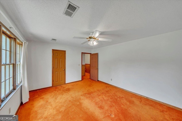 unfurnished bedroom featuring visible vents, light carpet, and a textured ceiling