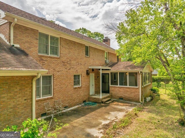 208 Earlwood Dr, Dublin, GA 31021 - rear view of property with a chimney, a patio, brick siding, and a sunroom