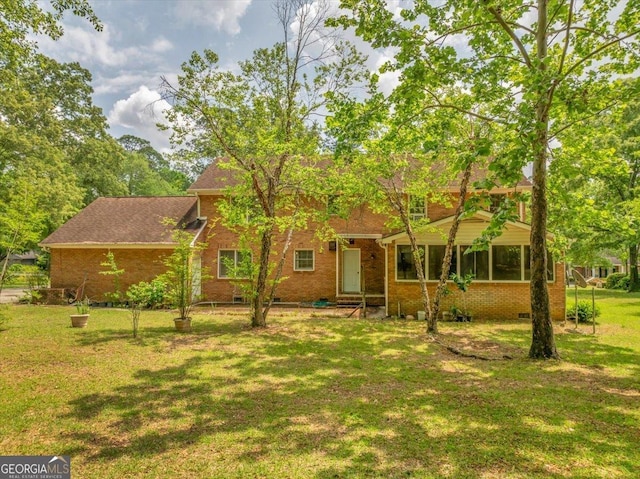 view of front of property with brick siding, a front yard, and crawl space