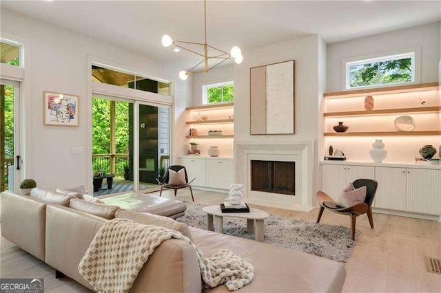 3006 Skyland Dr NE, Brookhaven, GA 30341 - living room featuring an inviting chandelier, a fireplace with flush hearth, and light wood finished floors
