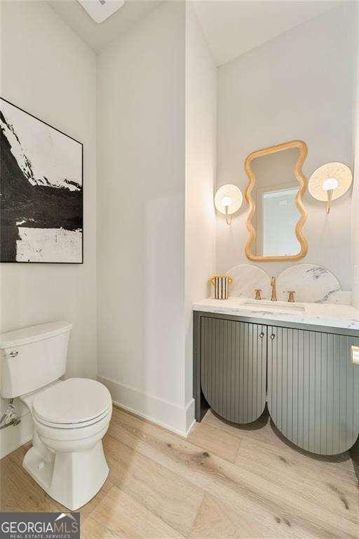 3006 Skyland Dr NE, Brookhaven, GA 30341 - half bath with baseboards, wood finished floors, toilet, and vanity