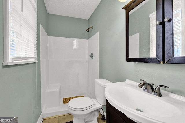 4850 Forest Blvd, Gainesville, GA 30506 - bathroom featuring a shower, a textured ceiling, vanity, and toilet