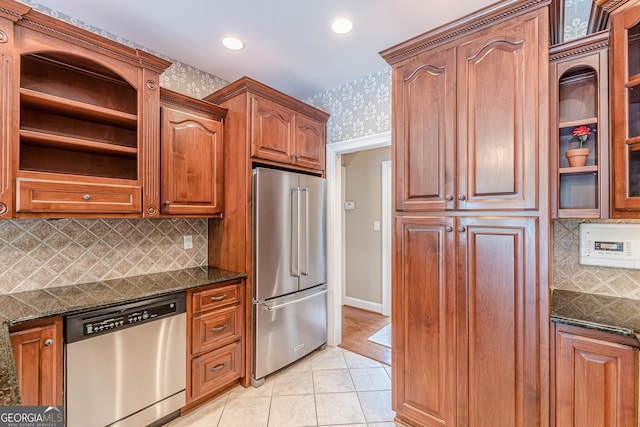kitchen with dark stone counters, light tile patterned floors, appliances with stainless steel finishes, wallpapered walls, and recessed lighting