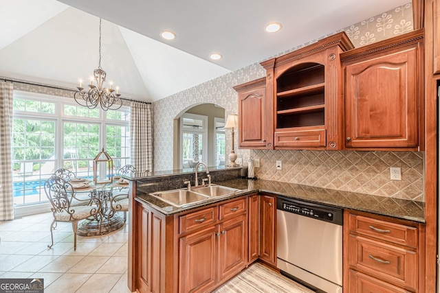 kitchen with wallpapered walls, dishwasher, a sink, a peninsula, and lofted ceiling