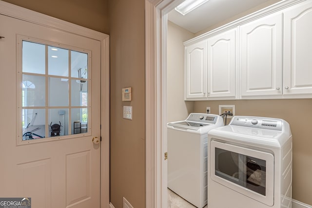 laundry area featuring baseboards, cabinet space, and washing machine and dryer