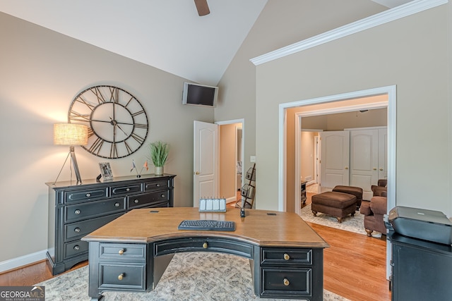 office featuring crown molding, ceiling fan, baseboards, light wood finished floors, and high vaulted ceiling