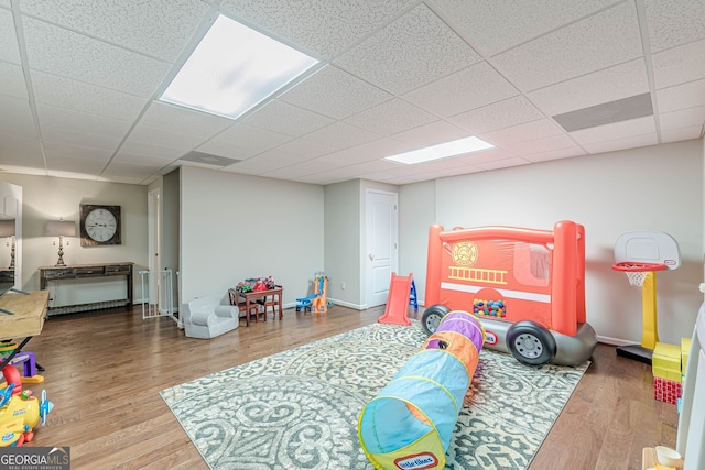 playroom with a drop ceiling, wood finished floors, and baseboards