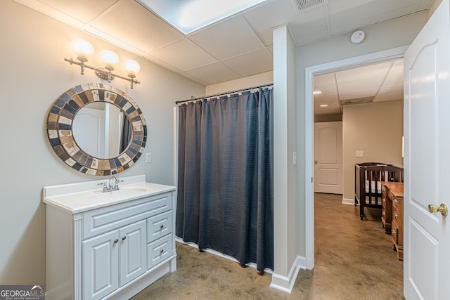 bathroom with a shower with shower curtain, vanity, baseboards, visible vents, and a paneled ceiling