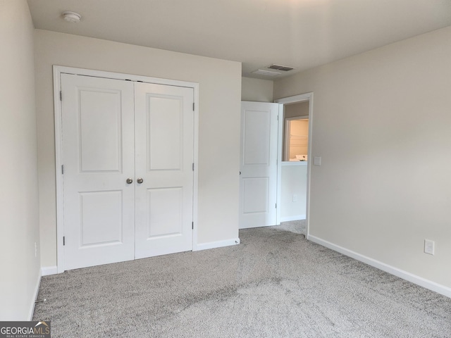 unfurnished bedroom with visible vents, a closet, carpet flooring, and baseboards