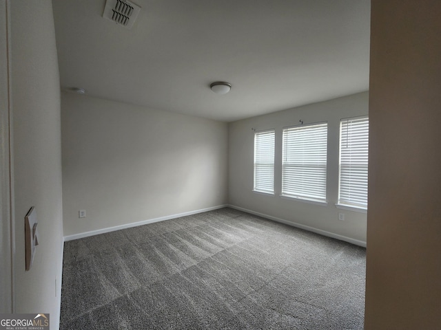 carpeted empty room featuring visible vents and baseboards