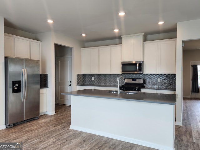 kitchen with dark countertops, a sink, backsplash, and stainless steel appliances