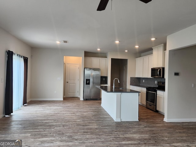 kitchen with recessed lighting, ceiling fan, backsplash, dark countertops, and appliances with stainless steel finishes