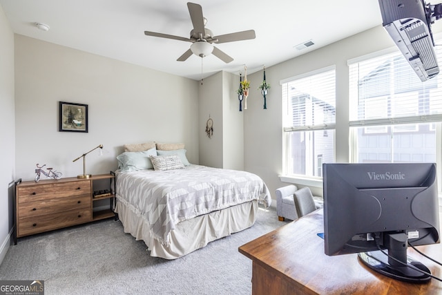 carpeted bedroom with baseboards, a ceiling fan, and visible vents
