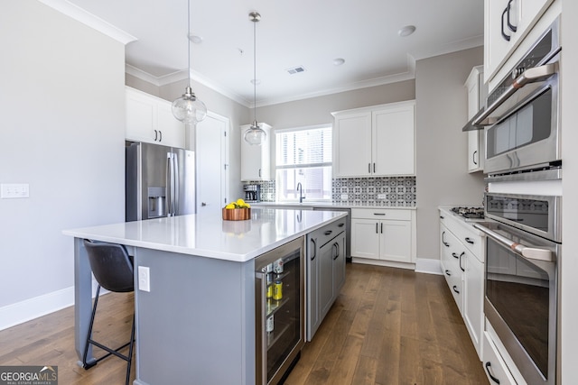 834 S Columbia Dr, Decatur, GA 30030 - kitchen with wine cooler, stainless steel appliances, decorative backsplash, a kitchen island, and a breakfast bar area