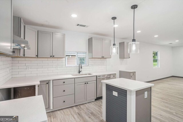 1477 Olive St SW, Atlanta, GA 30310 - kitchen with a sink, stainless steel dishwasher, gray cabinets, under cabinet range hood, and light wood-style floors