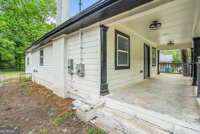 1477 Olive St SW, Atlanta, GA 30310 - view of property exterior with a chimney, covered porch, and a carport
