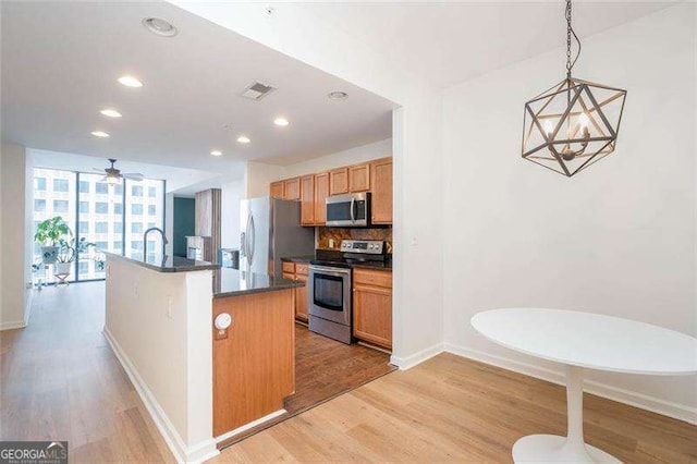 3040 Peachtree Rd NW Unit 815, Atlanta, GA 30305 - kitchen featuring appliances with stainless steel finishes, light wood finished floors, dark countertops, baseboards, and recessed lighting