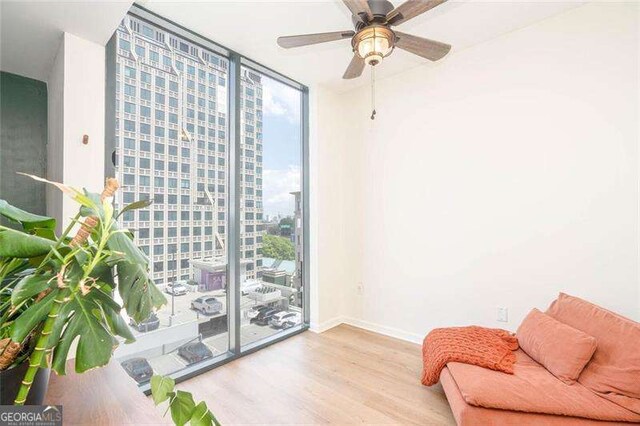 3040 Peachtree Rd NW Unit 815, Atlanta, GA 30305 - living area with a wall of windows, wood finished floors, baseboards, and ceiling fan