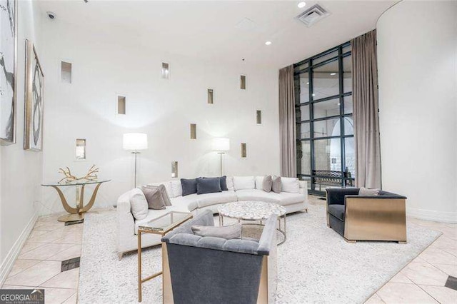 3040 Peachtree Rd NW Unit 815, Atlanta, GA 30305 - tiled living area featuring a towering ceiling, expansive windows, and baseboards
