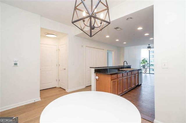 3040 Peachtree Rd NW Unit 815, Atlanta, GA 30305 - kitchen featuring dishwasher, a chandelier, baseboards, a center island with sink, and wood finished floors
