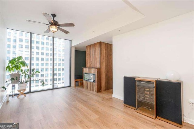 3040 Peachtree Rd NW Unit 815, Atlanta, GA 30305 - living room with floor to ceiling windows, a ceiling fan, light wood-type flooring, and a fireplace