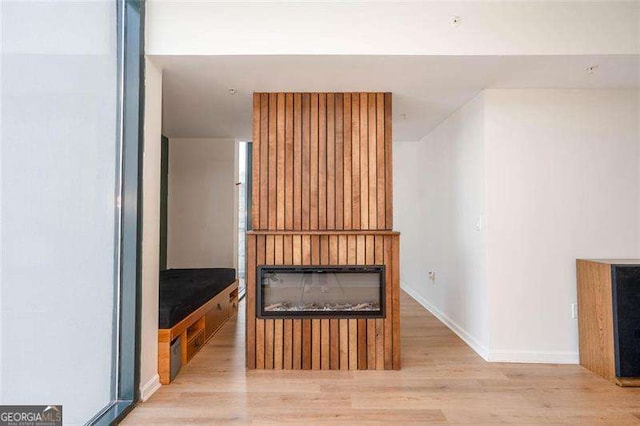 3040 Peachtree Rd NW Unit 815, Atlanta, GA 30305 - unfurnished living room featuring wood finished floors, baseboards, and a glass covered fireplace