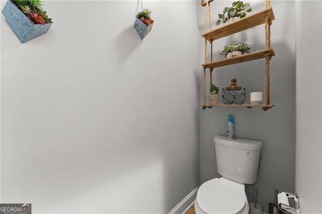 bathroom featuring toilet and baseboards