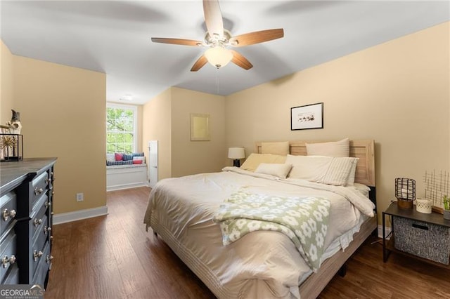 bedroom featuring dark wood-style floors, a ceiling fan, and baseboards