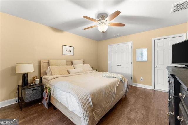 bedroom featuring baseboards, visible vents, ceiling fan, and dark wood finished floors