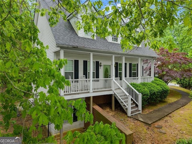 back of house with stairway, a porch, and a shingled roof