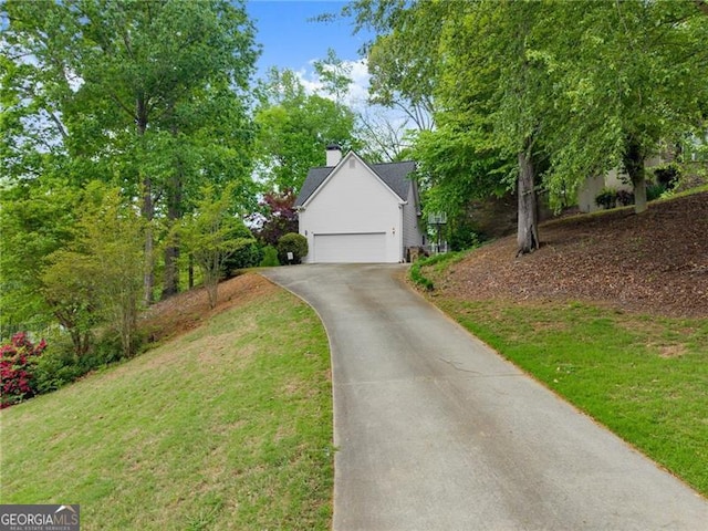 view of front of property with a garage, aphalt driveway, and a front lawn