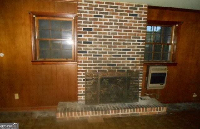 3296 Columbia Woods Dr, Decatur, GA 30032 - unfurnished living room with heating unit, wooden walls, and a brick fireplace