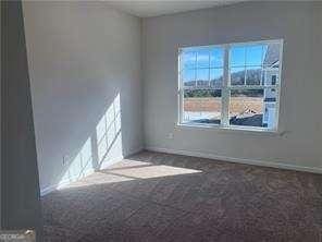 carpeted spare room featuring baseboards
